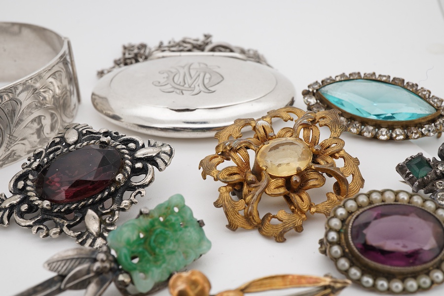A small collection of assorted costume jewellery, including a paste set crescent brooch and a spinning fob seal, together with a George V silver oval pill box, Adie & Lovekin, Birmingham, 1915, 52mm, with engraved monogr